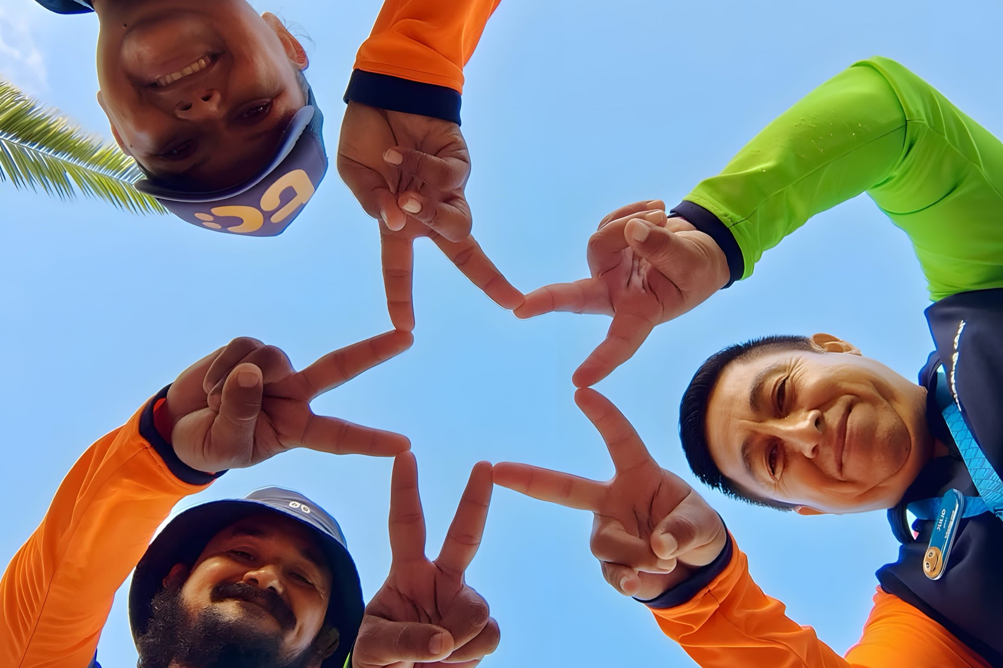 El equipo de Tripping Cool en la playa de Cozumel, formando una estrella con las manos.